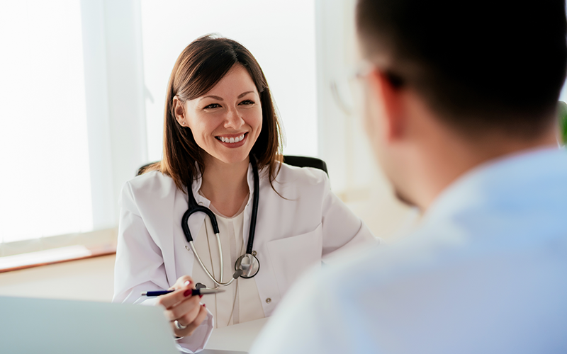 A smiling doctor consulting with a patient, representing the experienced and caring clinicians at Pivot Rehabilitation. The focus is on delivering high-quality, patient-focused care and achieving excellent therapy outcomes.